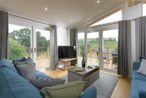 a living room with a blue couch and a tv at 4 Valley View in Looe