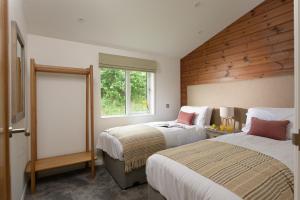 een slaapkamer met 2 bedden en een raam bij 4 Valley View in Looe