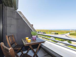 a table and chairs on a balcony with a view of the beach at Nautilus-12 in Kampen