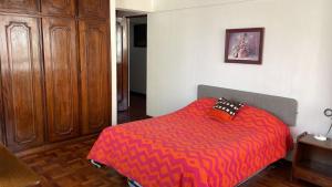 a bedroom with a bed with a red comforter at Edificio frente Club Tenis. in Cochabamba