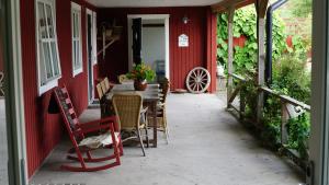 a patio with a table and chairs on a red house at Lekanders Bär & Boende in Tyfta