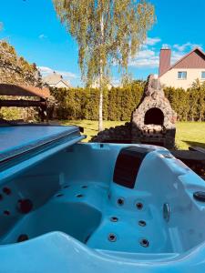 una bañera azul en un patio trasero con parrilla en Exclusive Jacuzzi Villa Kretinga en Kretinga