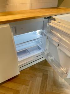 an empty refrigerator with its door open in a kitchen at Studion in Falun