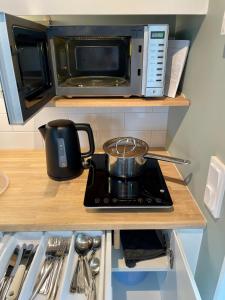 a kitchen counter with a stove and a microwave at Studion in Falun