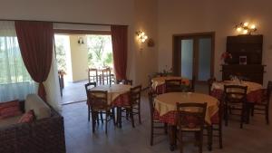 a dining room with tables and chairs and a living room at Agriturismo Gradec in Aurisina