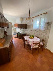 a kitchen with a table and chairs and a kitchen with a tableablish at A cas e Rosa in Ischia