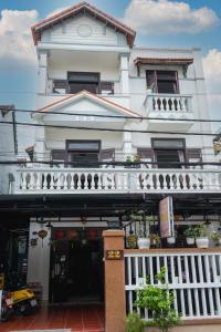 a white building with a balcony on a street at Hoi An Viet House Homestay in Hoi An