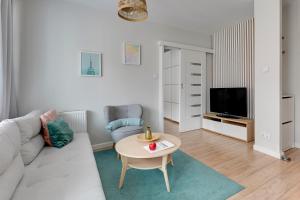 a living room with a couch and a table at Chmielna Park 5 TriApart® in Gdańsk