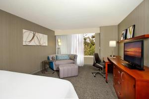 a hotel room with a bed and a desk and a television at Courtyard Oakland Downtown in Oakland