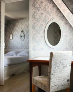 - une chambre avec une table, un miroir et un lit dans l'établissement Hôtel De La Mer - Deauville Blonville - Boutique Hôtel de charme vue Mer ou Campagne - Accès direct plage, à Blonville-sur-Mer