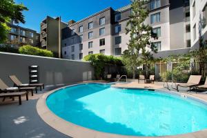 een groot zwembad met stoelen en een gebouw bij Courtyard Oakland Downtown in Oakland