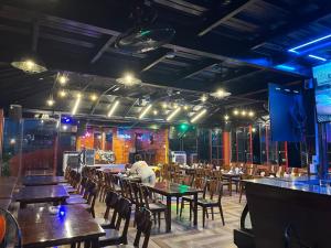 ハザンにあるRocks Ha Giang Hostel & Tourのテーブルと椅子のあるレストランのテーブルに座っている男性