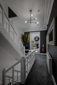 a hallway with a white staircase with a chandelier at Accommodation Fifty-Nine in Blackpool