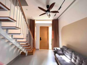 a living room with a couch and a ceiling fan at Central, Minimalist and Cozy - Gau's House in Da Nang