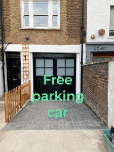 um sinal de estacionamento gratuito na porta de uma garagem em Amazing place in Finsbury Park em Londres
