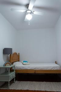 um quarto com uma cama e uma ventoinha de tecto em Casa dos Marianinhos em Elvas