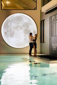 two people standing in front of a swimming pool at Ratri Hotel Phuket Old Town in Phuket