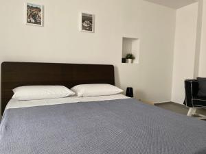 a bedroom with a large bed with a brown headboard at Al Duomo Rooms in Corato