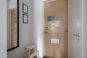 a wooden door in a room with a mirror at Hiisi Homes Turku Herttuankulma in Turku