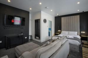 a hotel room with two beds and a tv at St Chads Suites by Central Beach Leisure in Blackpool