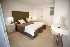 1 dormitorio con 1 cama grande y lavamanos en Hotel Cupidor en Paguera