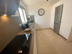 a kitchen with a counter and a clock on the wall at Casa Blanca Caleta - Golf & Sea Views - private heated Saltwater Pool - BBQ - Aircondition" in Caleta De Fuste