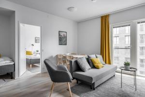 a living room with a couch and a table at Hiisi Homes Turku Herttuankulma in Turku