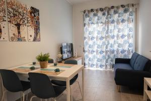 a living room with a table and a blue couch at antica dogana apartments scirocco in Terracina +6 photos