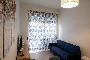 a living room with a blue couch and a window at antica dogana apartments scirocco in Terracina