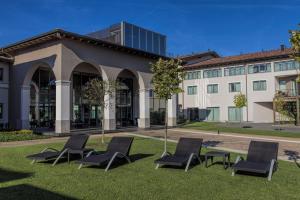 a group of chairs sitting on the grass in front of a building at Hotel & Residence Villa Bartolomea in Villa Bartolomea