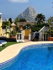 una piscina di fronte a una casa con una montagna di Casa Rose - 4-Bed villa with private pool in Calpe a Calpe