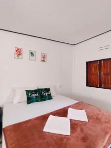 ein Schlafzimmer mit einem Bett mit zwei Handtüchern darauf in der Unterkunft Long beach simple House in Ko Lanta