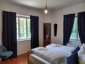 1 dormitorio con 2 camas, silla y ventanas en Ferienwohnung 'Bergidylle' - Zu Fuß auf die Loipe und den Berg, nur wenige Minuten ins Skigebiet, en Bayrischzell