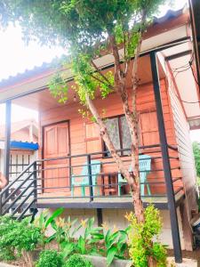 una casa con un porche y un árbol en Long beach simple House en Ko Lanta