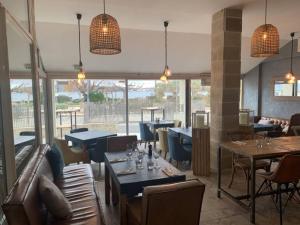 a restaurant with tables and chairs and windows at Studio ZEN SUD Plage à pied Pin Rolland Sablettes in Saint-Elme