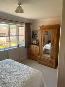 Goodwood Rooms في Charlton: غرفة نوم مع خزانة خشبية كبيرة وسرير
