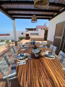 a dining room with a wooden table and chairs at Casa Blanca Caleta - Golf & Sea Views - private heated Saltwater Pool - BBQ - Aircondition" in Caleta De Fuste
