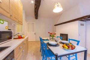 a kitchen with a table and blue chairs in a kitchen at Casa Gialla - Happy Rentals in Pugerna