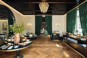 einen Salon mit grünen Vorhängen und Tischen mit Essen in der Unterkunft MS Collection Aveiro - Palacete Valdemouro in Aveiro