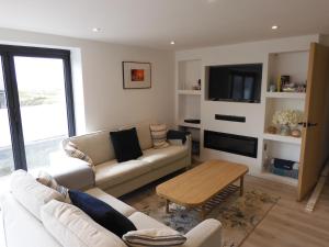 a living room with a couch and a table at Fabulous Ground Floor Apt Adjacent to Beach in Rhosneigr