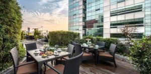 a patio with a table and chairs and a building at True Go S Hotel - Shenzhen Convention and Exhibition Center Union Square Branch in Shenzhen