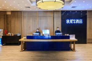two people sitting at a desk with their laptops at True Go S Hotel - Shenzhen Convention and Exhibition Center Union Square Branch in Shenzhen