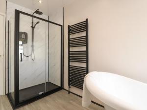 a bathroom with a shower and a white tub at Suite 14 in Blackpool