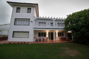 ein weißes Haus mit einer Veranda und einer Terrasse in der Unterkunft Villa Anievas in Boó de Piélagos
