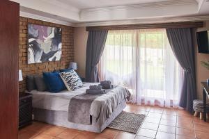 - une chambre avec un lit et une grande fenêtre dans l'établissement Eden Self Catering Clarens, à Clarens