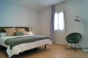 una camera con un letto e una sedia e una finestra di Luxury accomodations with coworking in Grazalema a Grazalema