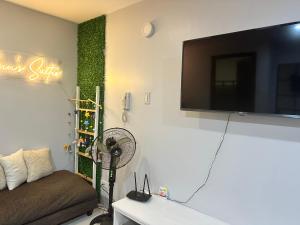 a living room with a fan and a tv on a wall at Ann’s Suites 2BR Mega1 w/parking in Baguio