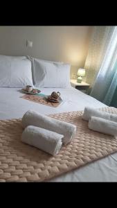 a bed with towels on it with a tray on it at Katerina Holiday House in Anavyssos