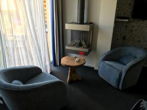 - un salon avec deux chaises et une table basse dans l'établissement Appartementen de Strandloper, à Bergen aan Zee