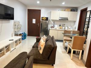 a living room with a couch and a kitchen at Ann’s Suites 2BR Mega1 w/parking in Baguio